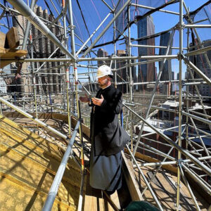Bishop Mesrop Parsamyan recently climbed the scaffolding surrounding St. Vartan Cathedral to offer a prayer at its summit, beside its gold dome.